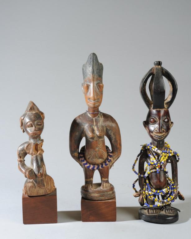 Yoruba Ere Ibeji and Senufo Tugubele Figures: Small carved Senufo female' tugubele' divination figure, offered together with two Yoruba female twin figures or Ere Ibeji. A Yoruba mother would bathe and care for the Ibeji, resulting in a silky smo