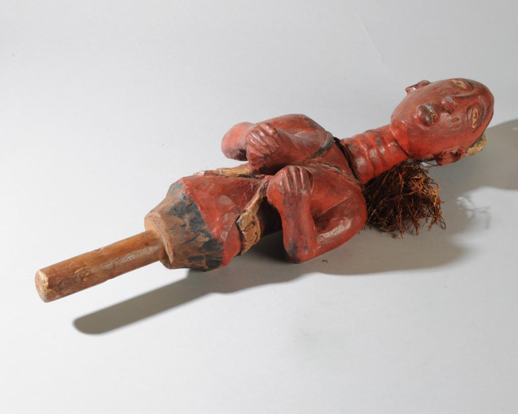 Baga Figural Dance Staff: Carved polychrome female figure with elaborate coiffure, long, ringed neck, hands cupping prominent breasts, crisscross body belt. Red, black and white paint. Raffia tassel at back of head. Approx. 23