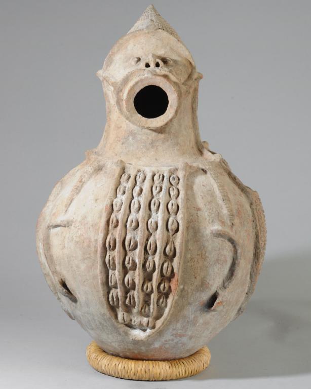 Nigerian Figural Pottery Vessel: Central Nigerian terracotta pot, probably a ritual form, an anthropomorphic vessel with helmeted head, the protruding round mouth forming the opening. Small simplified arms molded close to the body. A