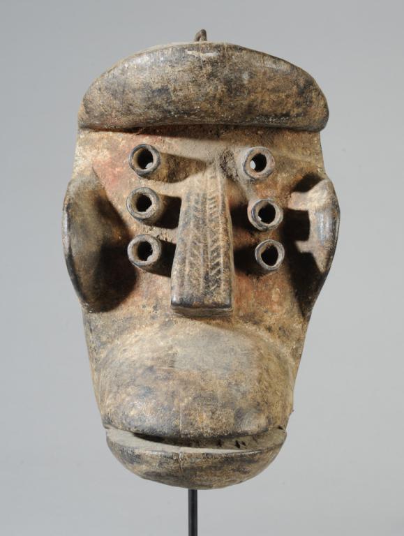 Dan Guere / We Mask: With protruding plate-like brow, cheeks and lips, and with six tubular eyes arranged three on each side of the straight nose, the flat front plane of the nose carved with a chevron pattern. Crusty sur