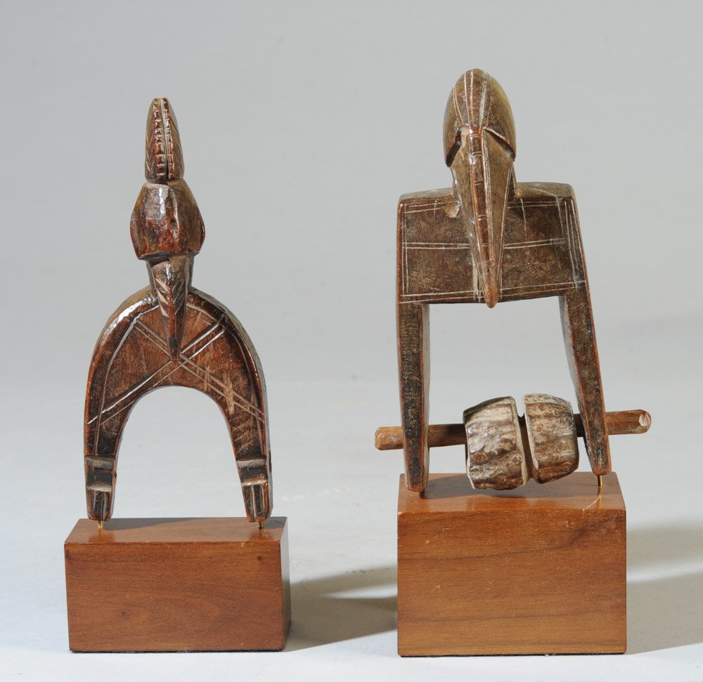 Two Senufo Heddle Pulleys: Of avian form, one with crested head, both with long beaks and incised decoration. On custom gallery stands. Pulleys, approx. 6" and 6 1/4" H. Provenance: Estate of Thomas McNemar, (1931-2020.) McNema