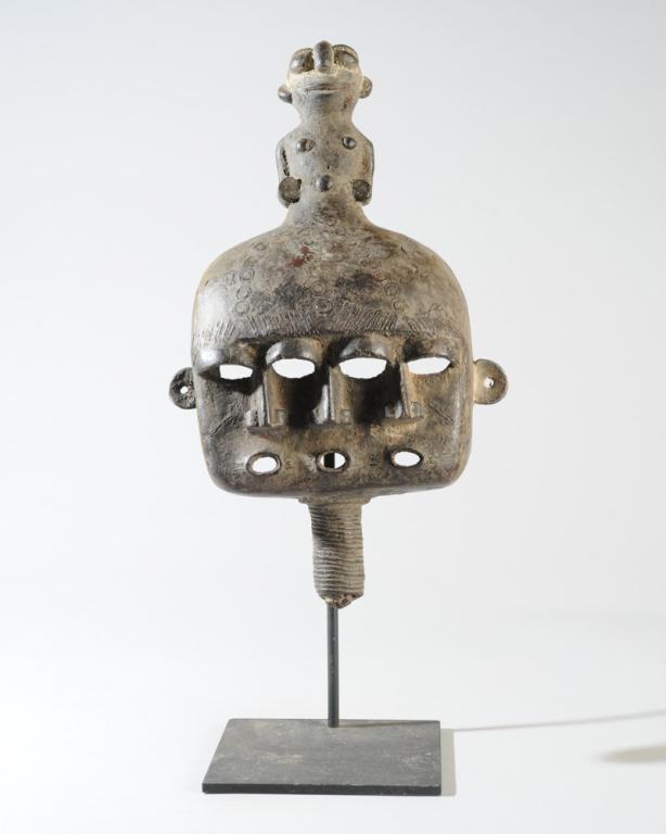 Lobi Cast Bronze Mask: Boxy mask with three faces with open mouths below an anthropomorphic finial. The post below the faces--possibly a neck or beard--terminates in a small face. Dark, blackish patina. On custom gallery st
