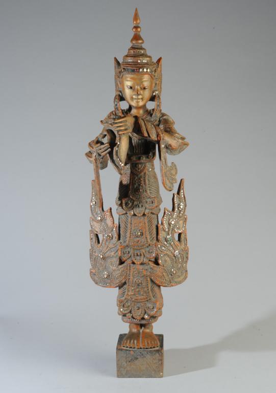 Antique Burmese Nat Shrine Figure: Early 20th century Mandalay style Burmese figure of a Nat holding a conch shell. The carved wooden figure, likely teak, is covered with orange-red thayo lacquer with finely molded details and inlaid w