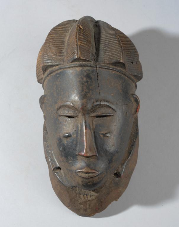 Fine Guro Mask, Ivory Coast: Anthropomorphic mask of marked delicacy, with lobed coiffure, half closed eyes under arched brows, slender nose and slightly pouting lips, with relief carved keloid scars on cheeks and temples. Old st