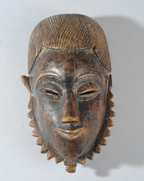 Yaure Mask, Ivory Coast: Superb Yaure mask with refined, delicate features, the upward slant of the coffee bean eyes beneath the arched brows and the upturned, slightly pouting mouth give an almost--but not quite-- flirtatiou