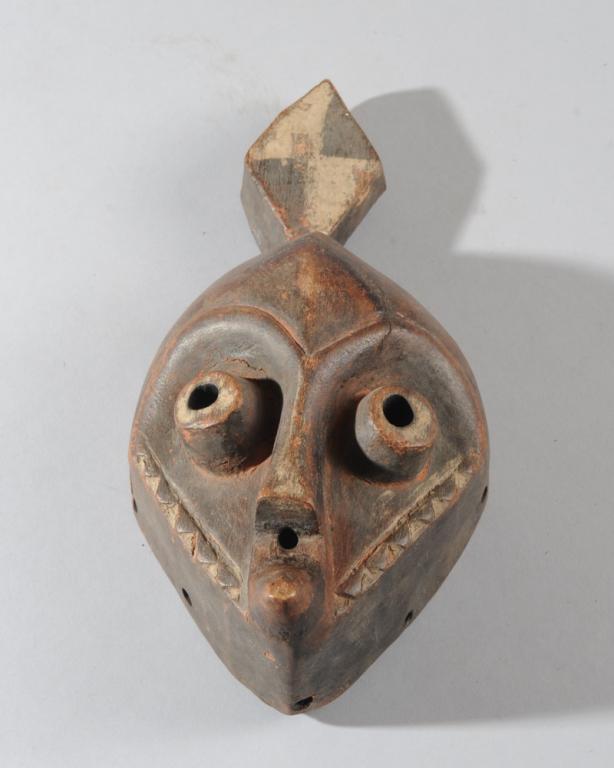 Eastern Pende Animal Mask: Perhaps representing a stylized antelope, with diamond shaped projection at top of head, heart shaped face with tubular eyes, small circular mouth and jutting chin and with characteristic relief-carve