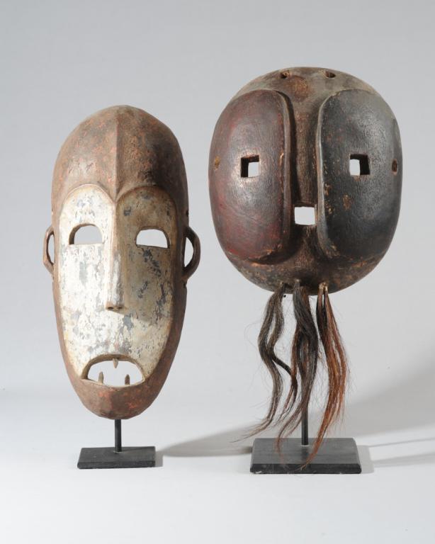 Lega Mask and Makonde Mask: Long, narrow and somewhat flattened Lega mask with whitened facial plane, cranial ridge extending to tip of long nose, three teeth in the open mouth, from the Democratic Republic of Congo. Offered tog