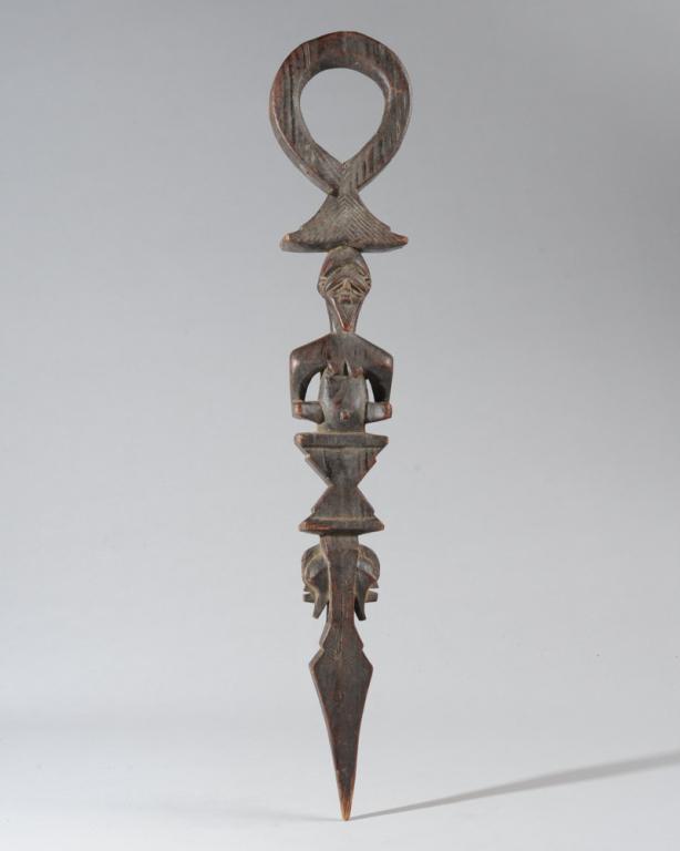 Songye Staff: Possibly a divination object or ceremonial scepter, with large circular hole above a bearded figure on a plinth, and below that two opposing Kifwebe masks over the pointed tip. Democratic Republic of 