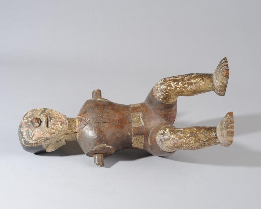 Akan Colonial Figure, Ghana: Seated male figure in colonial style belted shorts, white painted skin and flat hair. Arms and whatever he was seated upon are missing. Appears to have authentic age. Approx. 15 1/2" H. Provenance: Es