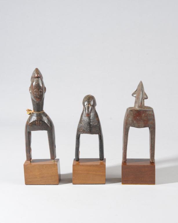 Three Senufo Heddle Pulleys, Ivory Coast: Two of avian form, the third with a human figure with typical crested coiffure. All on custom gallery stands. Tallest pulley, approx. 7 1/4" H, with stand approx. 9" H. Provenance: Estate of Thomas Mc