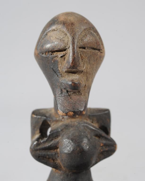 Small Songye Nkisi Figure: Diminutive carved wooden Songye personal power figure with typical mask like features, hands on each side of rounded abdomen. On custom gallery base. Figure, approx. 3 1/2" H., with base approx. 4 1/2