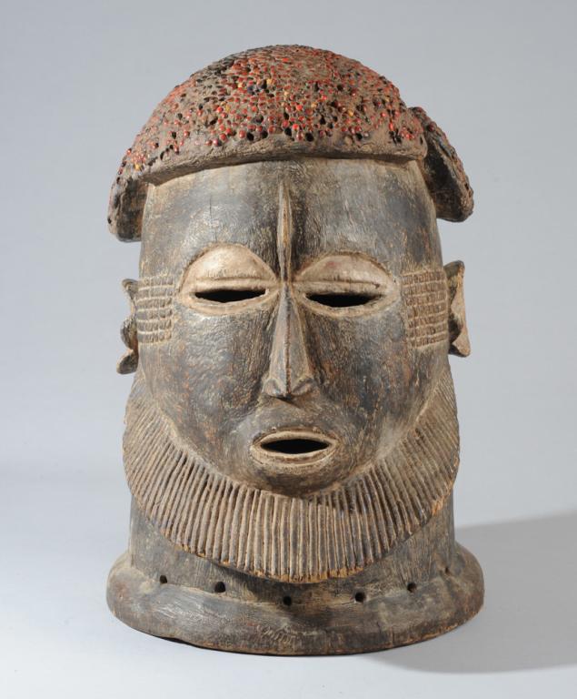 Igala Helmet Mask, Nigeria: Substantial carved wood helmet mask, the hairdo paved with red abrus seeds, the powerful face with relief carved scarification. Approx. 18" H, 14" D. Provenance: Estate of Thomas McNemar, (1931-2020.)