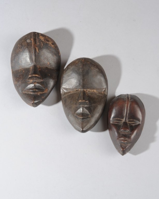 Three Dan Passport Masks: Miniature Dan deangle masks with typical tranquil expressions and refined features. Largest, approx. 5 3/4" x 3 3/4". Liberia. Provenance: Estate of Thomas McNemar, (1931-2020.) McNemar lived and coll
