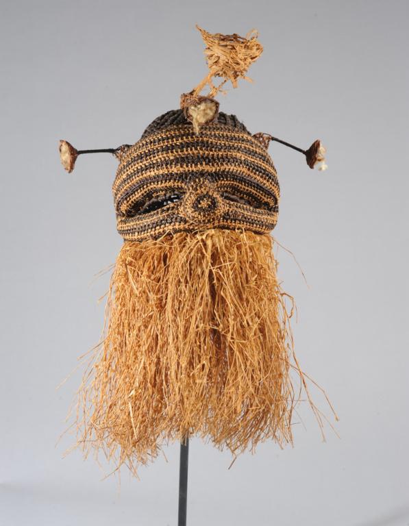 African Woven Raffia Mask: Possibly Kuba / Binji. Woven fiber cap mask with eye holes and dimensional nose, with wicker stalk-like projections each with a small basket or cup finial, the lower face with a thick raffia beard. On