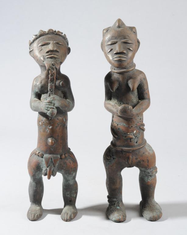 Baule Bronze Male & Female Figures: Standing couple, the male fingering his long beard, the female with lobed coiffure, hands held out and clasped in front of her torso. Baule artist, Ivory Coast. The taller figure (female) approx. 12" 
