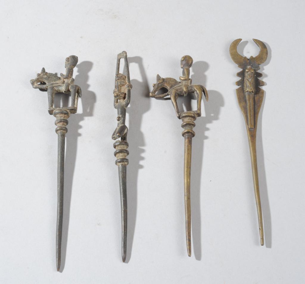 Four Dogon Figural Bronze Hair Pins, Mali: Two with equestrian finials, one a Telem type figure with arms in the air, the fourth a small figure against a beetle shaped plate. Longest, approx. 6 1/2" L. Provenance: Estate of Thomas McNemar, (19