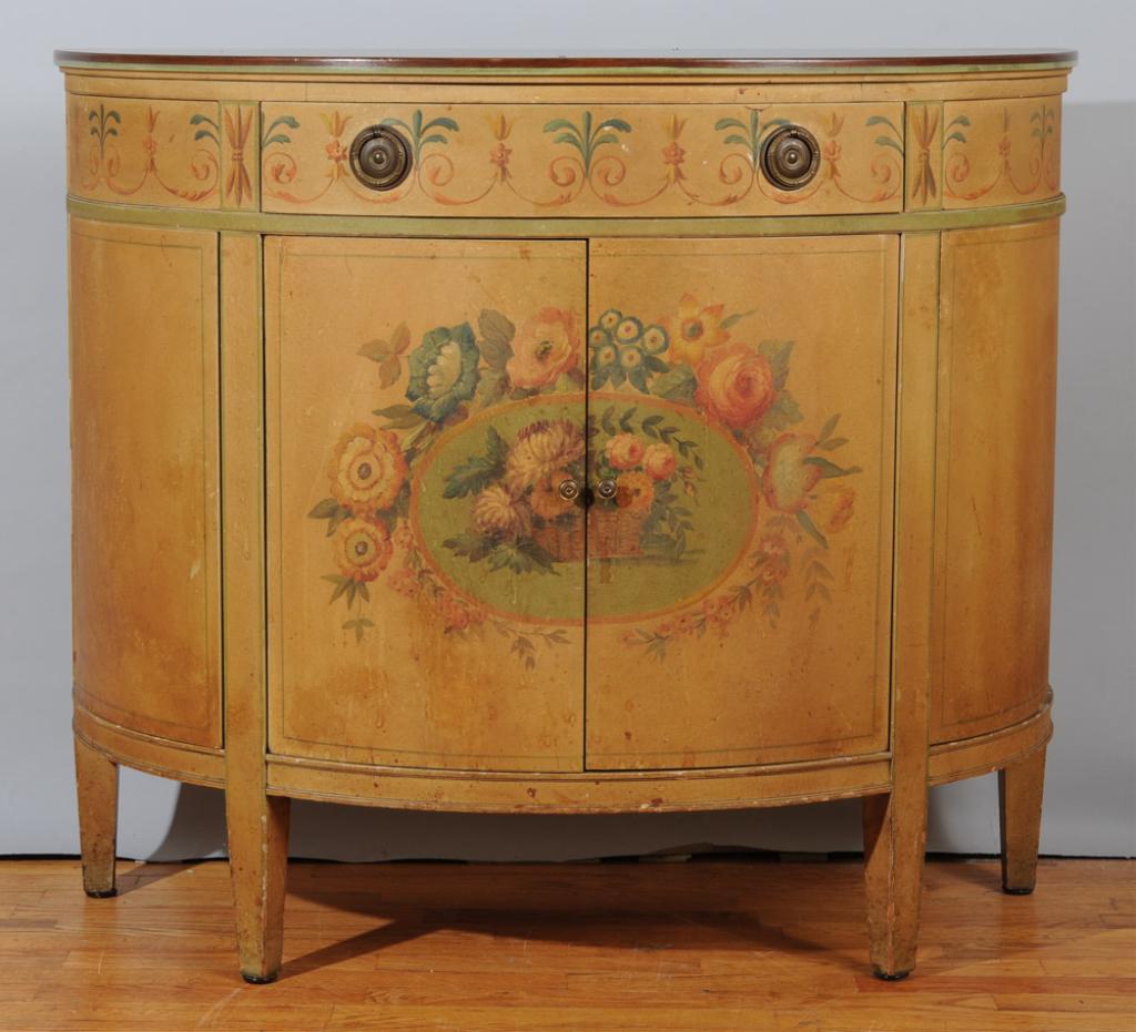 Painted Demilune Chest: Demilune chest with floral motif, single drawer with brass pulls over double doors opening to shelf, flanked by two single doors, square tapered legs.H: approx. 34".W: approx. 40".D: approx. 18".