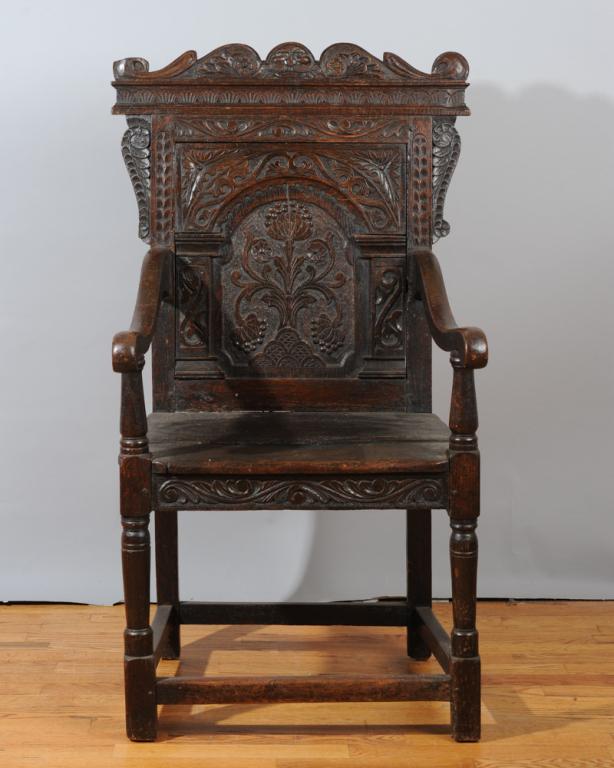 17th C. Jacobean Carved Oak Armchair: Probably Scottish, pegged construction, with carved thistles in the central area of the splat and crest with carved ocean waves and north face blowing a mighty wind.H: approx. 44"W: approx. 25 1/4"D: 