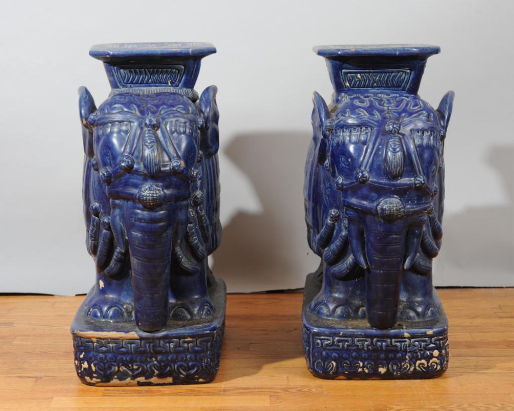 Matched Pair Chinese Ceramic Elephant Stools: Elaborately garbed ceramic elephants bearing flat platforms as stools or small tables, with vibrant cobalt blue glaze. Likely first half 20th C. H: approx. 23 1/2"W: approx. 10"D: approx. 20"
