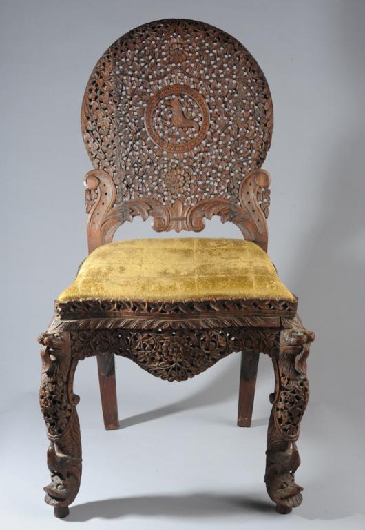 19th C. Burmese Carved Wooden Chair: Lavishly carved Anglo-Indian side chair of Burmese origin, the pierced back with foliate carving and a lion or similar creature in the center, the legs with beasts and birds. H: approx. 35 1/2"
