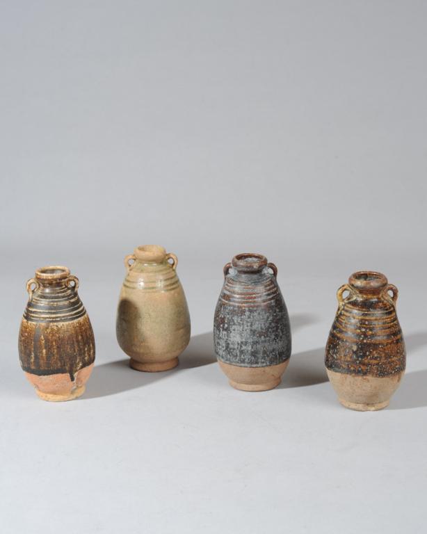 Four Sawankhalok Sukhothai Jarlets: Ming dynasty jars, one with celadon glaze, the remaining three with variegated brownish black to brown glazes, all with looped 'ear' handles, lower quarter and base unglazed. 4 3/4" - 5" H.