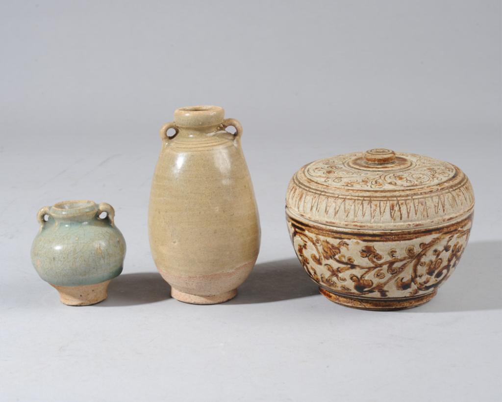 Sawankhalok Ceramics Group: Three antique Thai Sawankhalok pottery items, to include a round brown glazed box and cover with incised flower scrolls, a small blue-green celadon glazed jarlet with two round 'ear' handles, and a sm