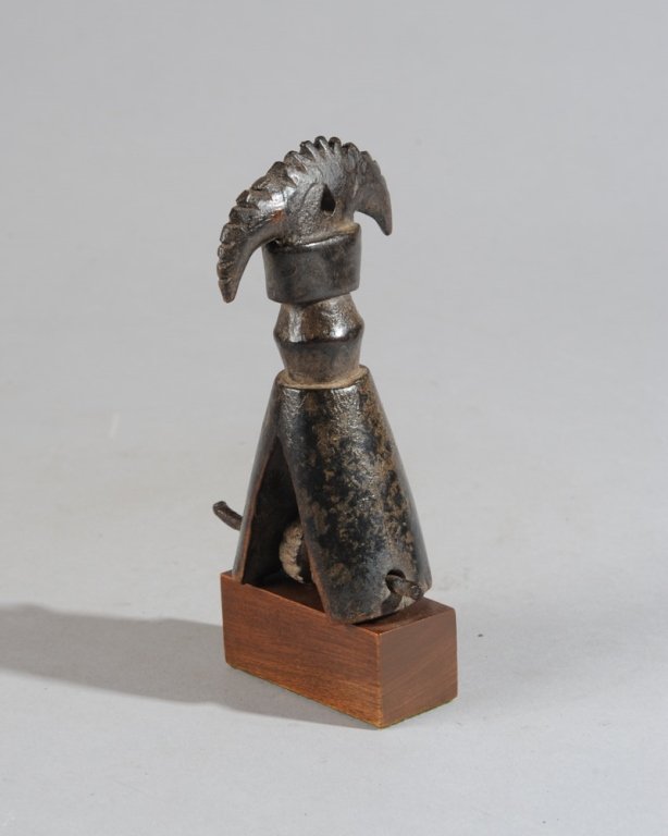 West African Heddle Pulley: Of abstract avian form, with crested head, triangular base. Mounted to custom gallery stand. Pulley, approx. 5" H. Provenance: Estate of Thomas McNemar, (1931-2020.) McNemar lived and collected throug