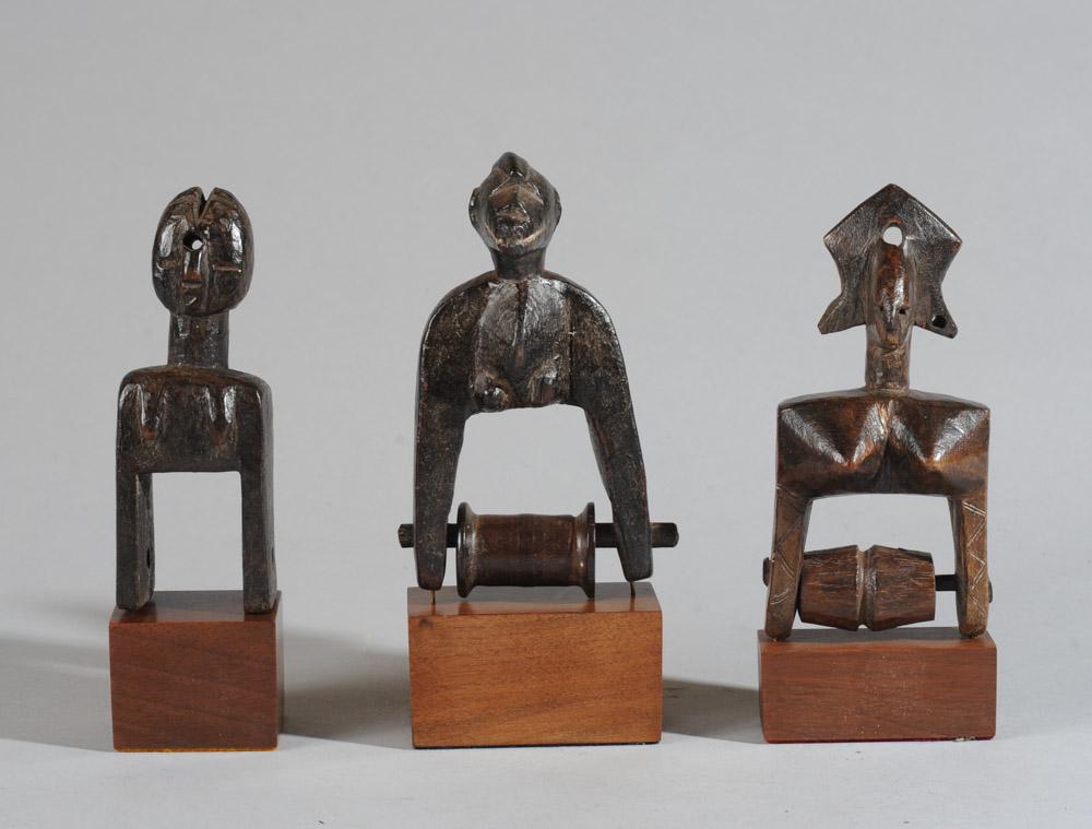 Three Figural African Heddle Pulleys: To include a Bamana pulley, Mali, a Senufo pulley, Ivory Coast, and the third pulley possibly Guro, Ivory Coast. Includes custom gallery stands. Tallest pulley approx. 5 1/2" H. Provenance: Estate of 