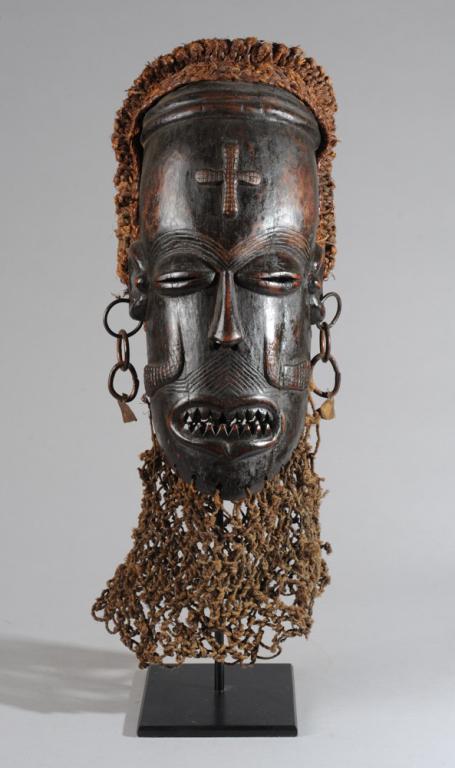 Chokwe Pwo Mask with Accoutrements: Female ancestor mask with relief carved cross on high forehead, raised facial scarification, coffee bean eyes, with fiber coiffure, metal earrings. Includes custom gallery stand. Mask approx. 17" x 9"