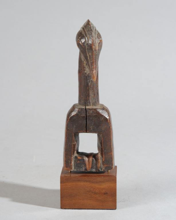 Senufo Avian Heddle Pulley, Ivory Coast: Heddle pulley with finial in the form of a Hornbill bird, with crested head and long beak. Includes custom gallery base. Pulley, approx. 7" H. Provenance: Estate of Thomas McNemar, (1931-2020.) McNema