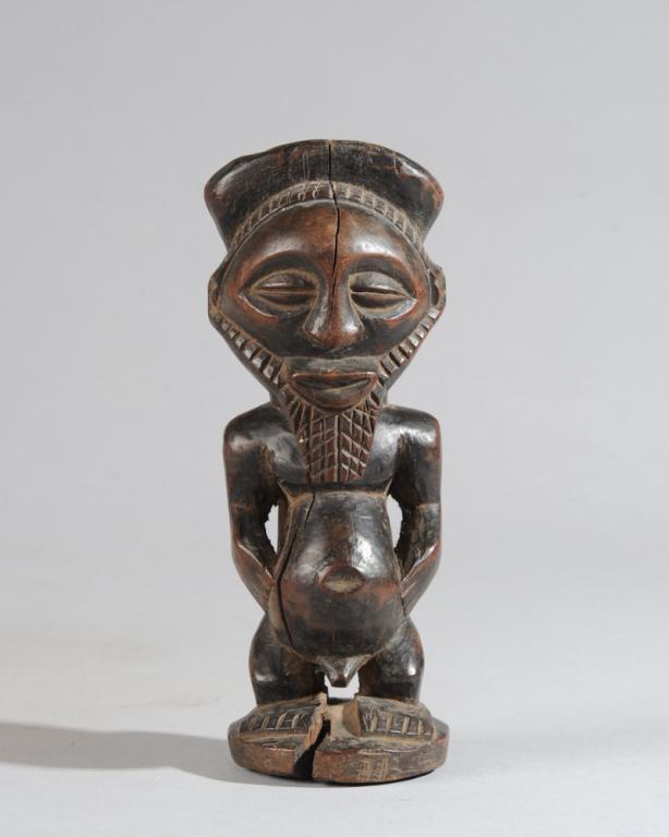 Luba Male Figure: Standing male figure with round forehead, coffee bean eyes, long braided beard, standing on truncated legs with hands cupping protruding abdomen. Approx. 7" H. Provenance: Estate of Thomas McNemar, (1