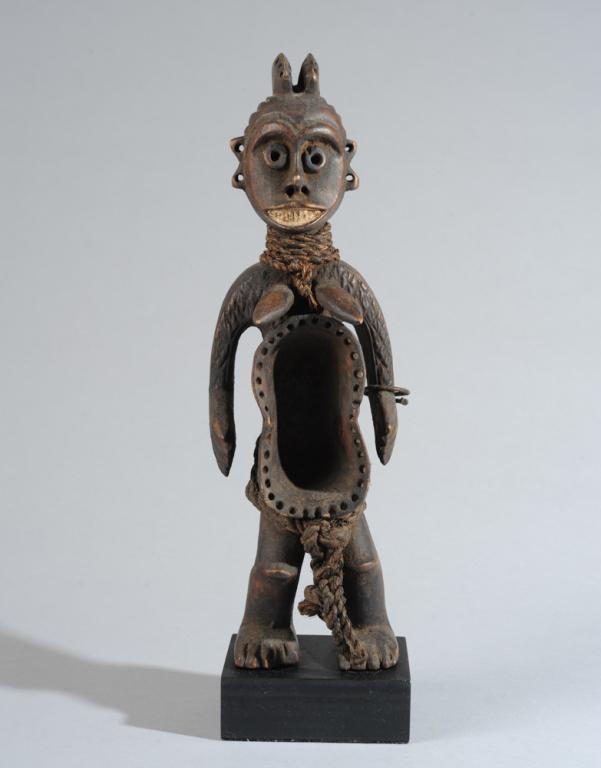 Koro Anthropomorphic Cup Figure: Standing female figure, the abdomen carved as a double cup, having the unusual addition of a row of holes along its edge. Such cups are used for the ritual drinking of palm wine. Fiber ropes at neck a