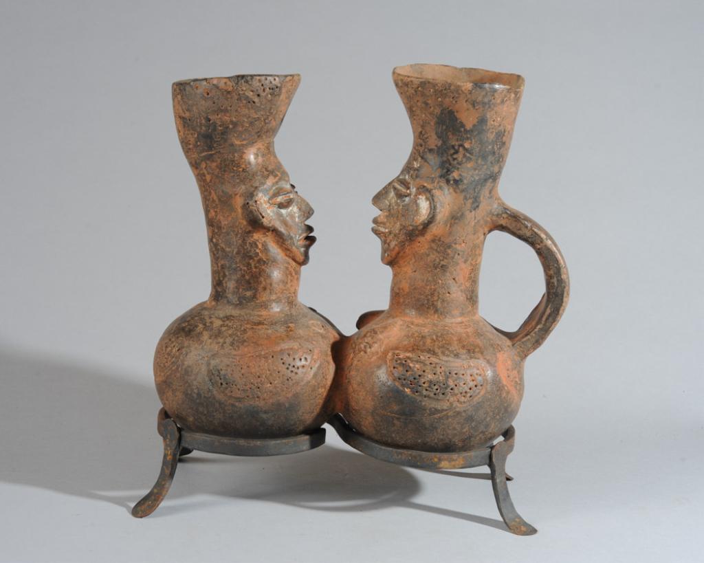 Mangbetu Figural Double Terracotta Vessel: Figural palm wine vessel in the form of two facing figures, both with the elongated head and high, flaring crown of braids that embodies the Mangbetu ideal of elegance. (The inspiration for Beyonce's 