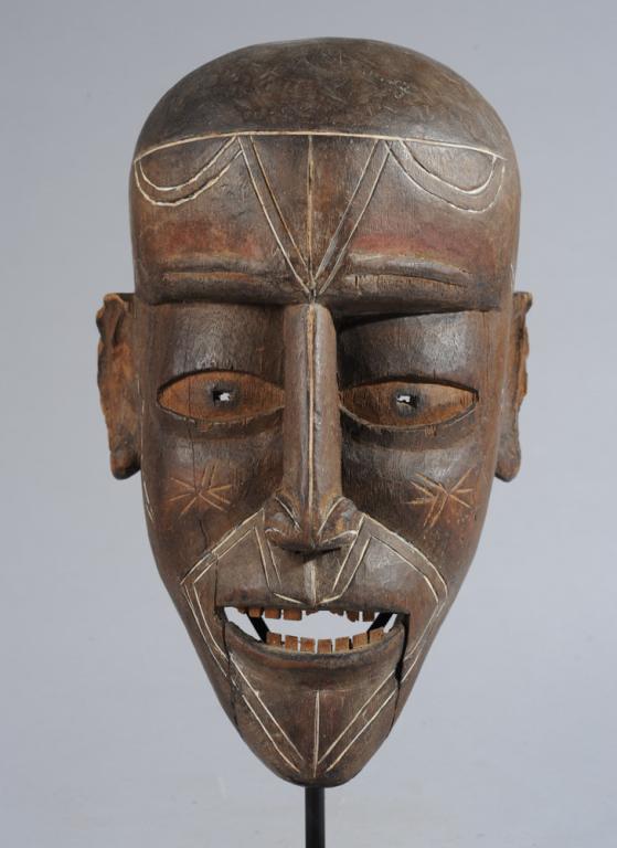 Fang or Vili Mask: Anthropomorphic mask with realistic features, the expressive mouth especially rendered with parted lips and individually carved upper and lower teeth. Incised patterns to brow, temples, cheeks, nose,