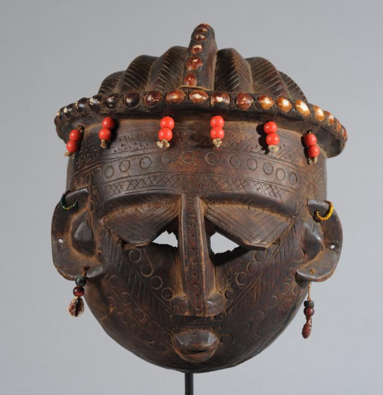 Bamana Mask, Mali: According to the collector's notes, a 'Jobali' mask, likely a female character in certain traditional dances. This mask with plaited coiffure embellished with shells and red beads, the round face with