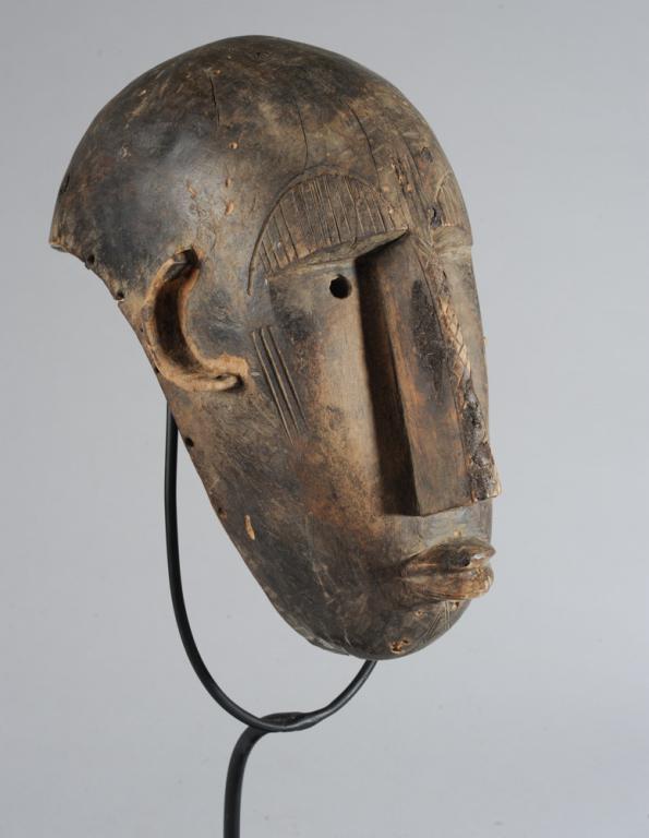 Bamana Mask, Mali: Anthropomorphic helmet mask with deep set eyes, elongated nose, 'c' shaped ears, incised facial scarification. Includes custom gallery stand. Mask, approx. 12" x 10" x 7 1/2". Provenance: Estate of Th