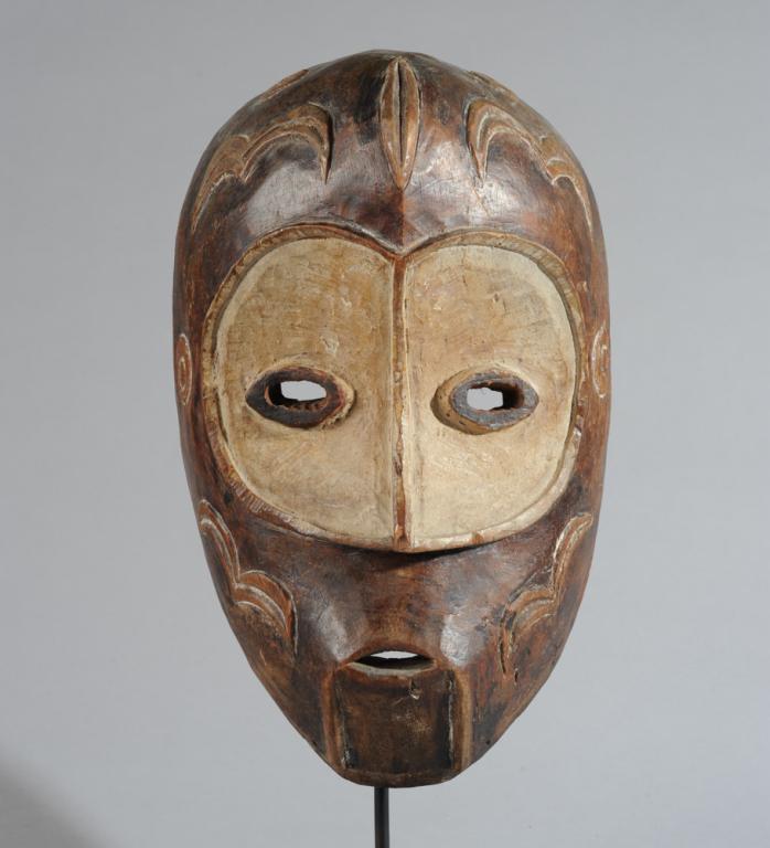 Bena Lulua Mask, D. R. Congo: With heart shaped concave area from brows to to tip of nose surrounding relief carved almond shaped eyes, the brow, temples and cheeks with relief carved emblems. Includes custom gallery stand. Mask,