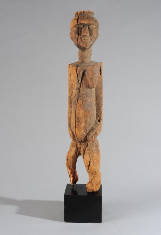 Dogon Figure, Mali: Standing female figure, vigorously carved, the form simplified to the essentials, conveying great dignity and strength. Weathered, dry, and with old insect damage, one leg reinforced with copper wire 