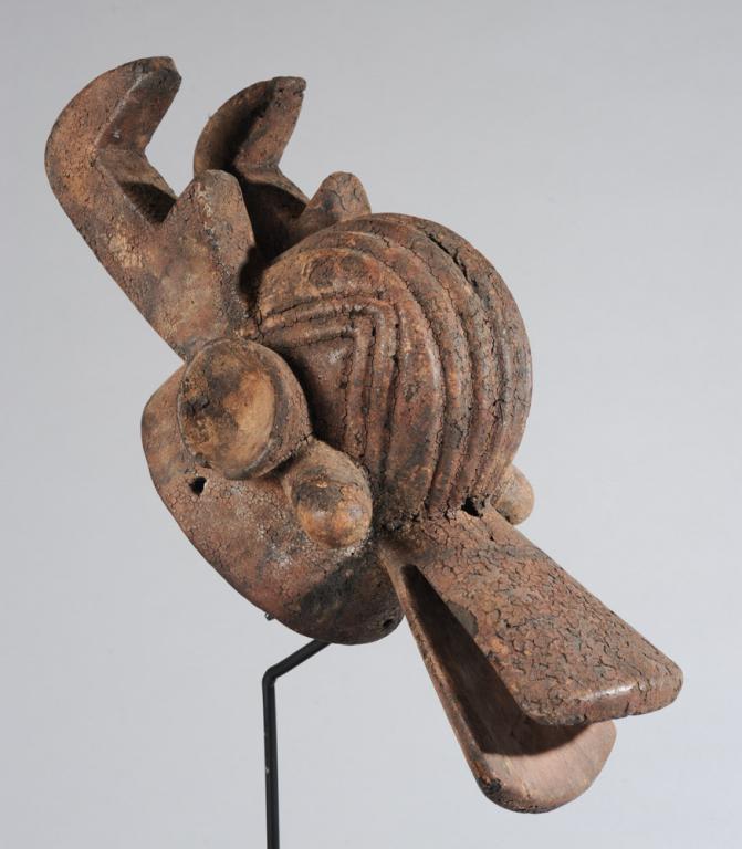Chamba Mask, Nigeria: Bush spirit mask incorporating the horns of a buffalo and the long snout of a crocodile. Encrusted surface. Includes custom gallery stand. Mask, approx. 19" L x 9" H x 8" W. Provenance: Estate of Thom