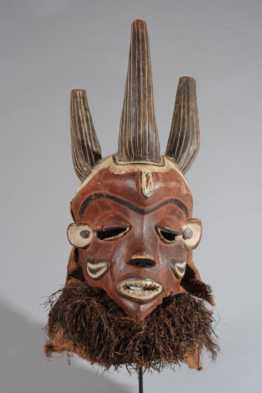 Pende Mask, Congo: Phumbu / Pumbu Mbuya mask, with four large striated horns rising above a face displaying typical Mbuya mask features including bulging forehead; large, half-closed eyes; sharp cheekbones; short, a alm