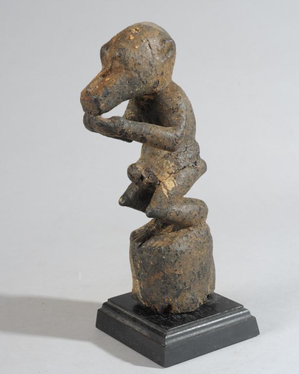 Baule Monkey Fetish Figure, Ivory Coast: Small carved wood figure of a monkey, heavily encrusted with blood, eggshells, other ritual material. On custom gallery stand. Figure, approx. 10" H, with stand approx. 11 1/4" H. Provenance: Estate o