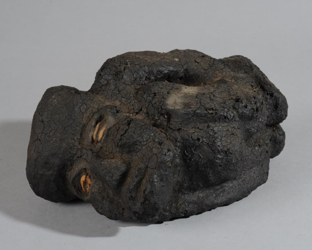 Dan Kran Fetish Type Figure: Anthropomorphic reclining figure made of dense material, heavily encrusted, black surface, with inset cowrie shell eyes, possibly a Kran fetish figure, Liberia. Heavy for its size. Approx. 9" x 6" x 5