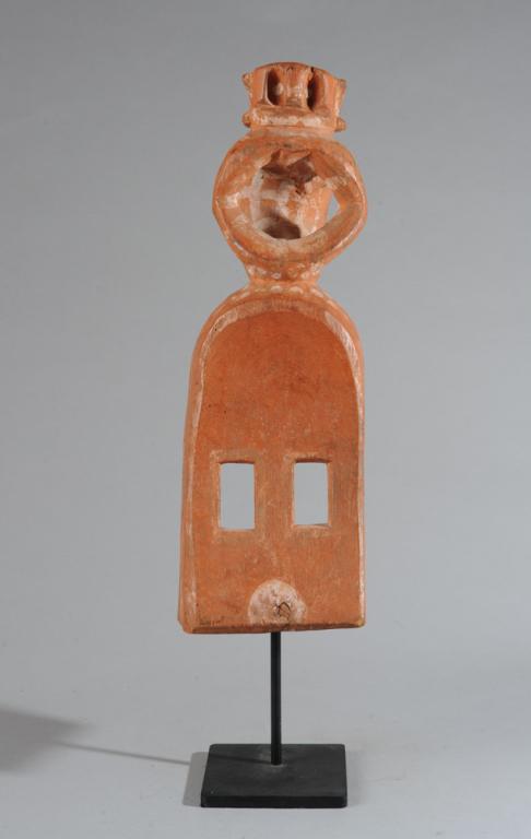 Dogon Style Mask: With vertical rectangular eyes, finial of a crouching monkey or similar figure, the surface stained with reddish pigment and kaolin. Includes custom gallery stand. Mask, approx. 19 1/2" x 6" x 6". Pro