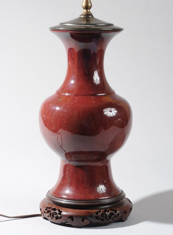 Chinese Flambe Baluster Vase as Lamp: Dynamic glaze with warm sang de boeuf red at the base and streaks of violet at the neck. Mounted as lamp with handsome waisted carved wood base. Vase alone approx. 14" H. Height to top of socket appro