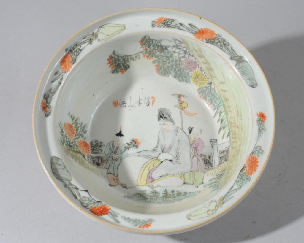 Chinese Qianjiang Bowl: Bowl with a scene of a sage or immortal in a garden with two little boys, with inscription in two red seal marks, the broad rim with chrysanthemums in vases, the exterior with foliage in red enamel. U