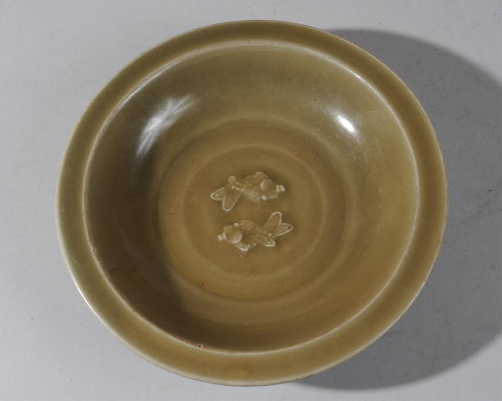 Ming Chinese Celadon Twin Fish Bowl: Deep olive celadon bowl with two spiny fish circling one another in the center. Underside with molded lotus leaves. Unglazed foot rim. Approx. 8 1/4" diameter, 1 3/4" in height. Acquired in Asia in th