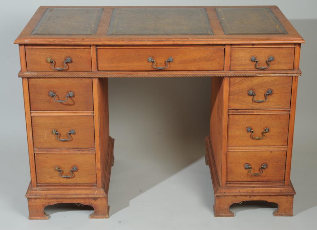Sleigh Pedestal Desk: Molded edge top with leather inserts, nine dovetailed drawers with brass pulls, bracket feet. Damage to molding and leather / in as-found condition.H: approx. 30 1/2".W: approx. 42".D: approx. 21".