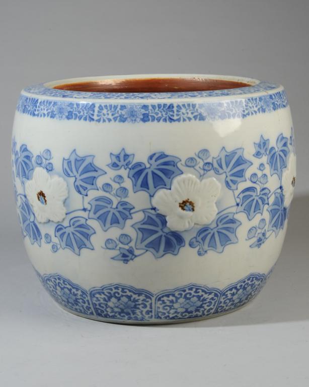 19th C Japanese Blue & White Jardiniere / Fishbowl: Large Meiji period porcelain jardiniere or fish bowl with central decoration of flowering and fruited vine, the large white flowers molded in relief and with red centers. Floral lappet border at base,