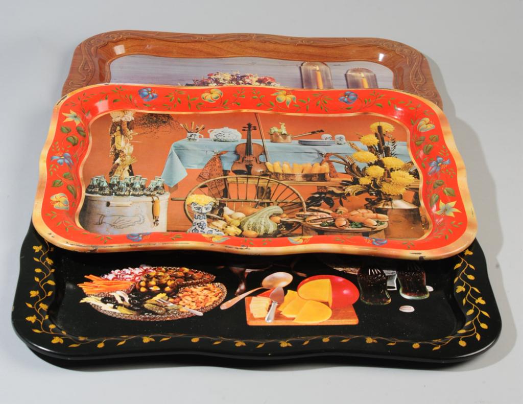 Three Coca Cola Scaloped Edge Trays: One with a fondue pot, one with a feast including ham and a glass of coke, the other with a violin and crock of cokes, some scuffs.Approx. 13 1/2" x 18 3/4".