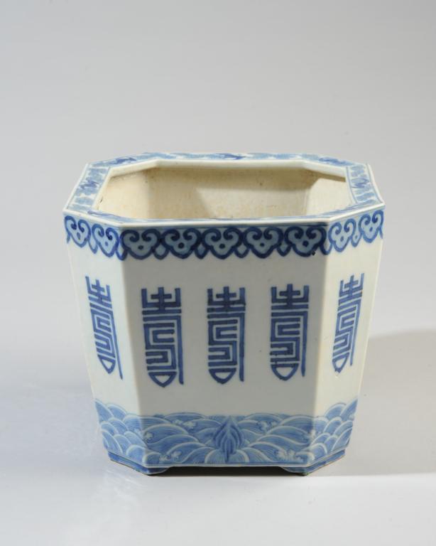 Chinese Blue & White Octagonal Jardiniere: Octagonal jardiniere on four feet, the rim with bats among clouds, with ruyi border above wide central band of auspicious symbols, and with a border of waves along bottom edge. Base unglazed, no mark.